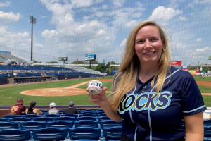 Treasurer Colleen Davis wearing a Wilmington Blue Rocks jersey holding a baseball