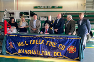 Treasurer Davis watches as Governor Carney signs House Bill 371