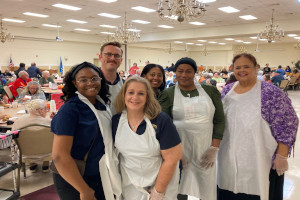 OST staff serving Thanksgiving lunch to people at Modern maturity Center